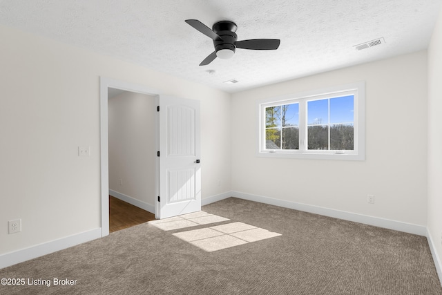 unfurnished bedroom with carpet, baseboards, visible vents, and a textured ceiling