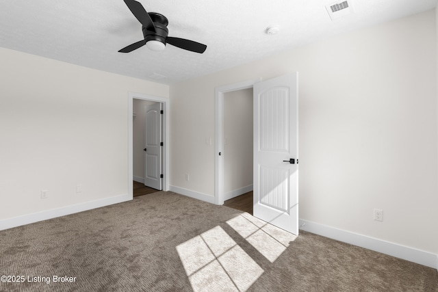 unfurnished bedroom with carpet flooring, visible vents, and baseboards