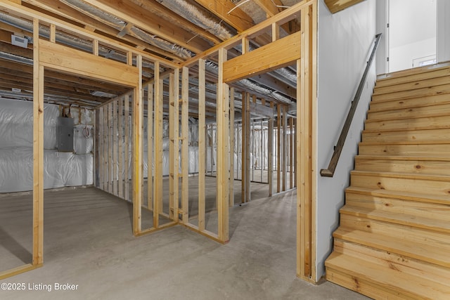 unfinished basement featuring stairway and electric panel