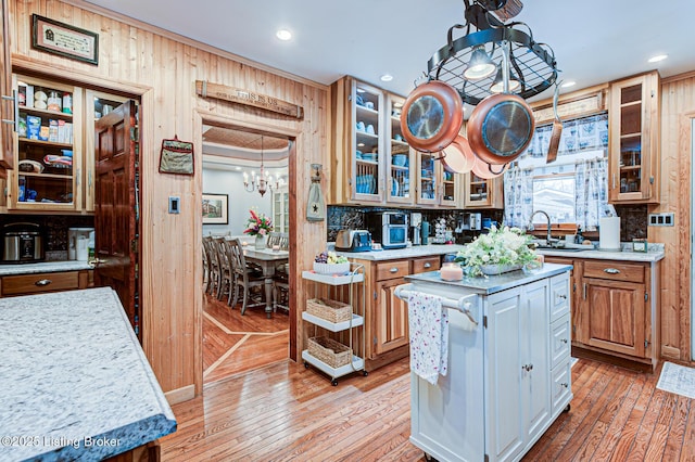 kitchen featuring light wood-style floors, tasteful backsplash, glass insert cabinets, and light countertops