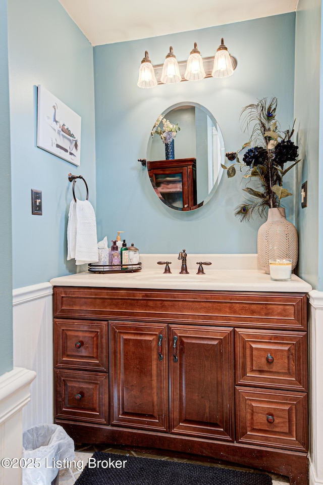 bathroom with toilet, wainscoting, and vanity