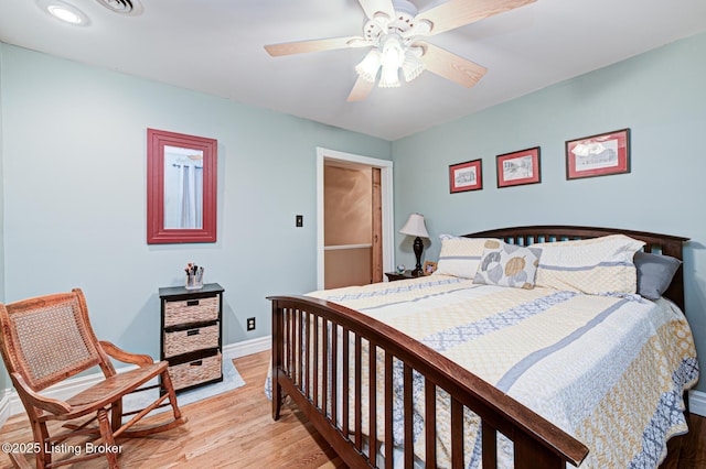 bedroom with light wood-type flooring, baseboards, and a ceiling fan