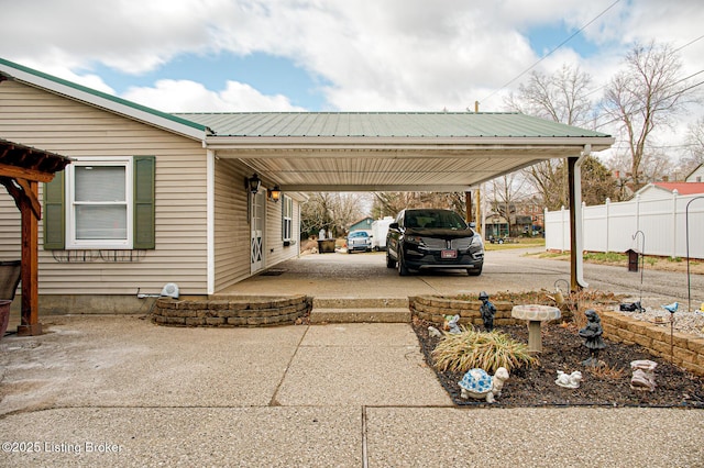 view of parking featuring a carport, driveway, and fence