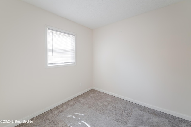 unfurnished room with carpet and baseboards