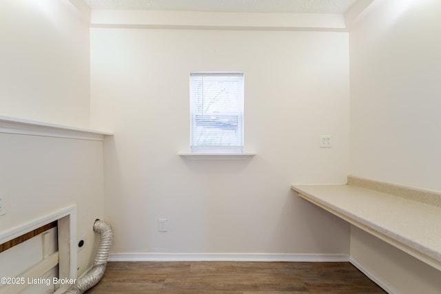 clothes washing area featuring laundry area, wood finished floors, baseboards, and electric dryer hookup