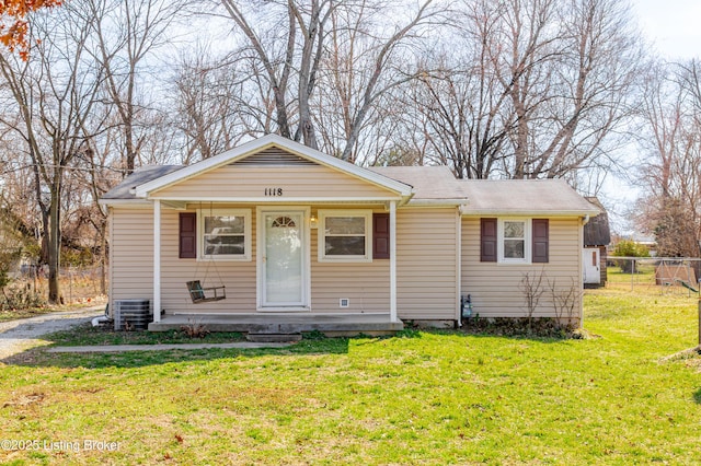 view of front of house featuring cooling unit, a front lawn, and fence