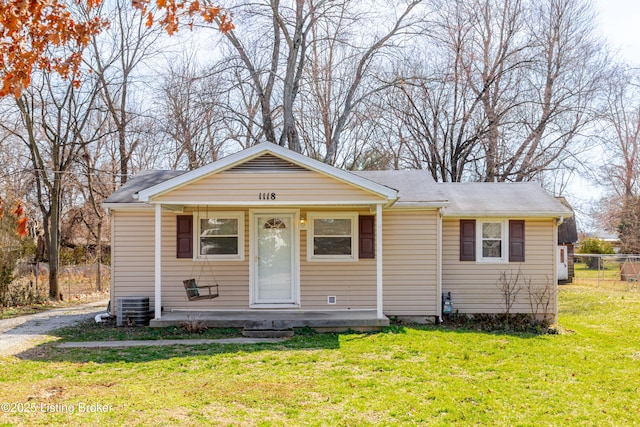 view of front of house with a front yard, central AC unit, and fence