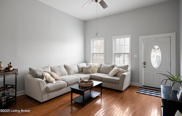 living area with ceiling fan, baseboards, and wood-type flooring