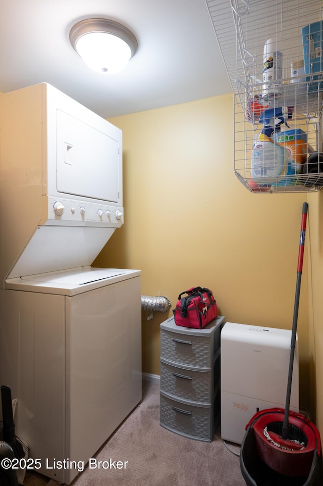 laundry area with laundry area, carpet, and stacked washer and clothes dryer