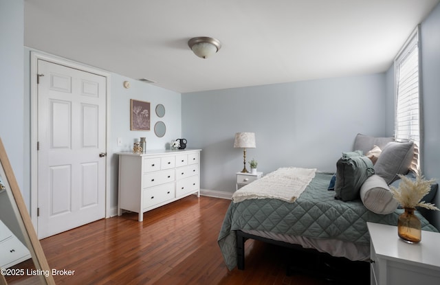 bedroom featuring visible vents, dark wood-style flooring, and baseboards