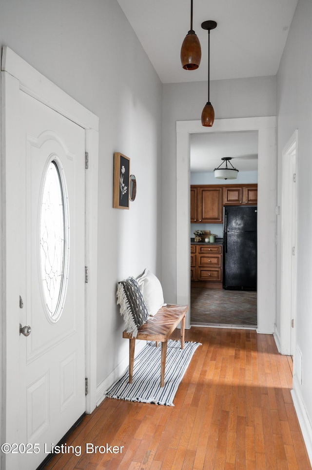 foyer with baseboards and light wood-style floors