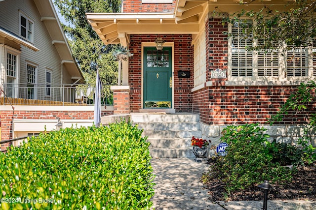 view of exterior entry featuring brick siding