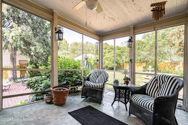 sunroom / solarium featuring wood ceiling and a ceiling fan