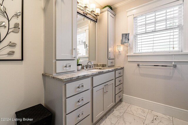 bathroom featuring crown molding, marble finish floor, vanity, and baseboards