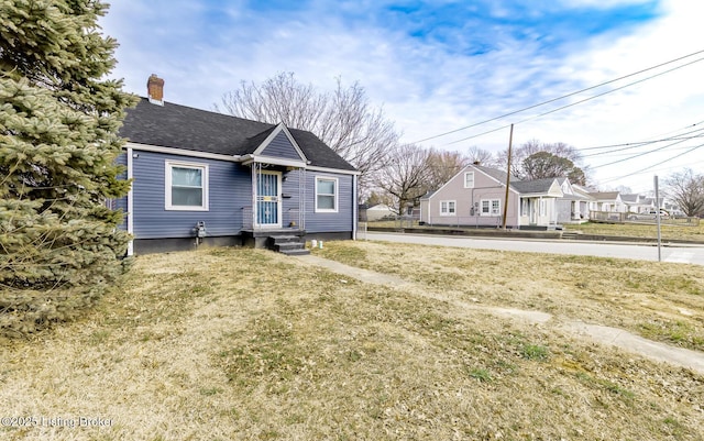 bungalow featuring a shingled roof and a chimney