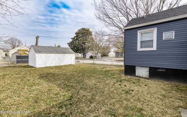 view of yard with an outbuilding, fence, and a shed