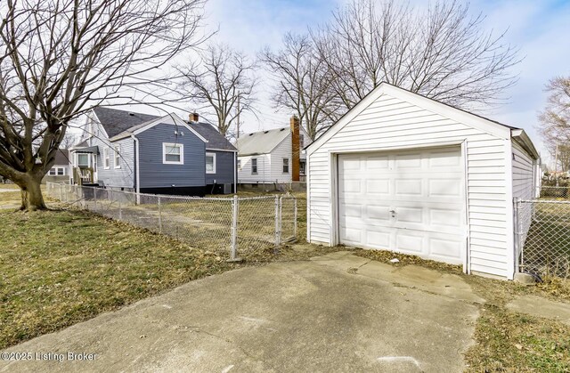 detached garage featuring driveway and fence