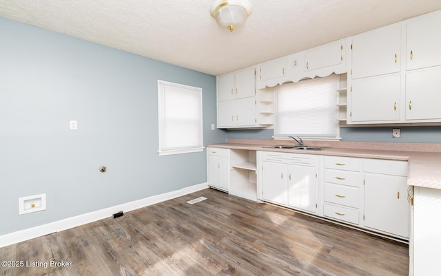 kitchen featuring baseboards, dark wood-style floors, white cabinetry, open shelves, and a sink