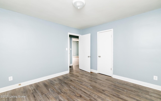 unfurnished bedroom featuring wood finished floors and baseboards