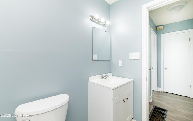 bathroom featuring vanity, toilet, and wood finished floors