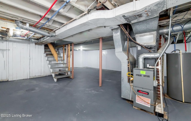 unfinished basement featuring water heater and stairs