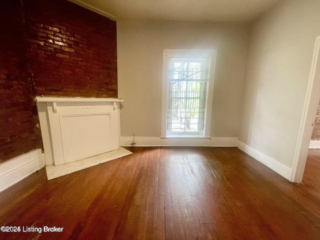 unfurnished living room featuring wood finished floors and baseboards