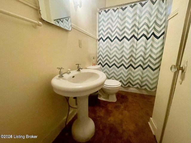 bathroom with a sink, toilet, and a shower with curtain