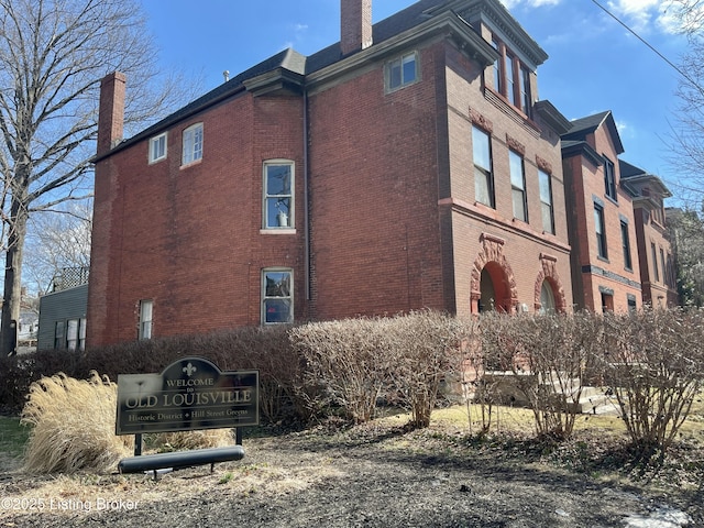 view of home's exterior featuring brick siding and a chimney