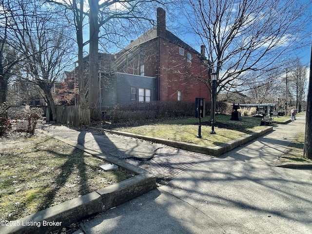 view of side of property featuring a lawn and fence