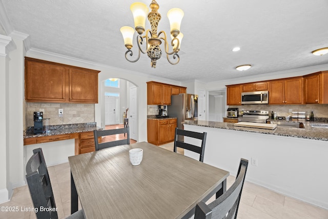 dining room with light tile patterned floors, a textured ceiling, arched walkways, and crown molding