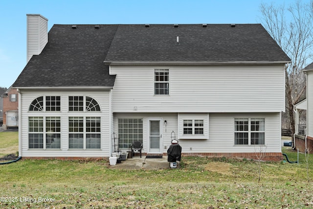 rear view of house with a patio area, roof with shingles, a lawn, and a chimney