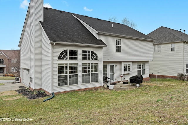 rear view of property with a garage, driveway, a shingled roof, a chimney, and a yard