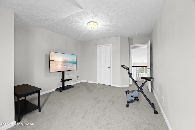 workout room with a textured ceiling, carpet, and baseboards