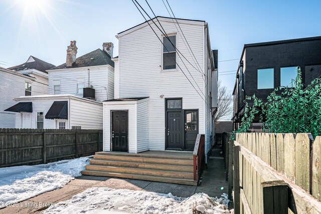 view of front of property with central AC and a fenced backyard