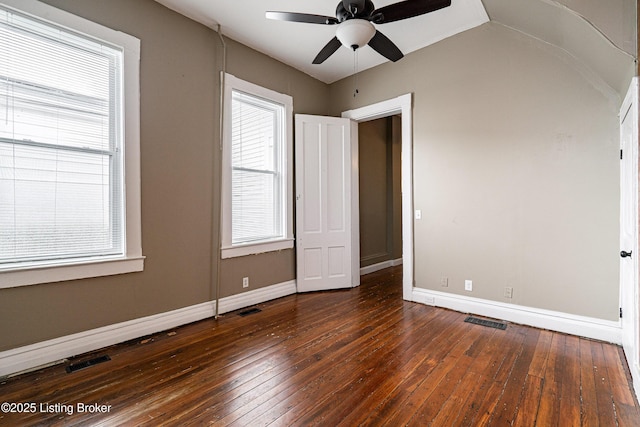 unfurnished bedroom with baseboards, visible vents, multiple windows, and hardwood / wood-style flooring