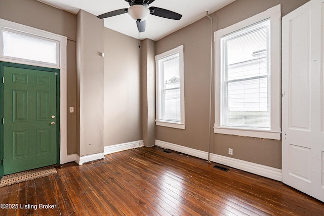 foyer with a healthy amount of sunlight, baseboards, visible vents, and dark wood finished floors