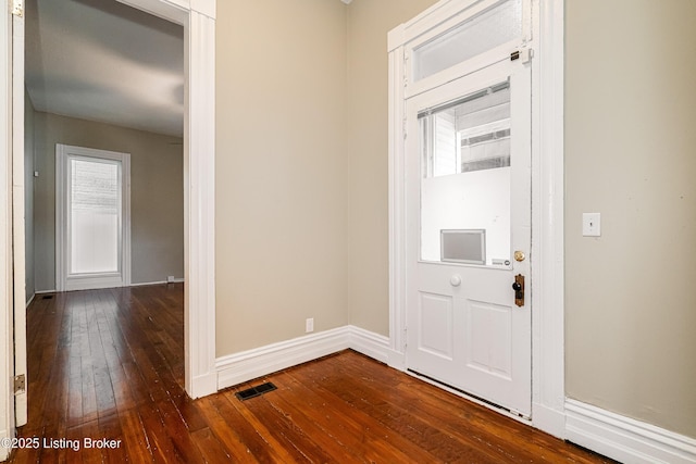foyer entrance featuring dark wood-style floors, visible vents, and baseboards
