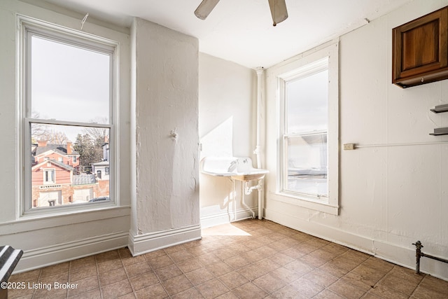 unfurnished room featuring ceiling fan, tile patterned floors, and baseboards