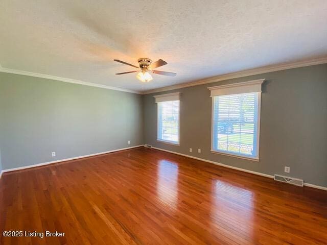 spare room with ceiling fan, baseboards, wood finished floors, and visible vents