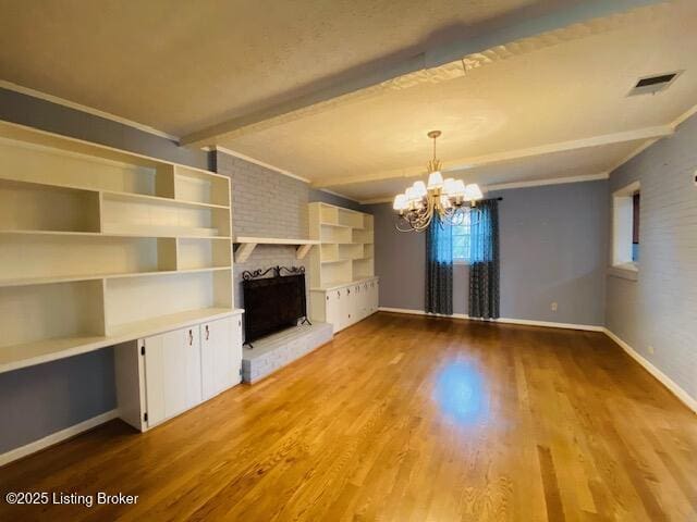 unfurnished living room with crown molding, a brick fireplace, and wood finished floors