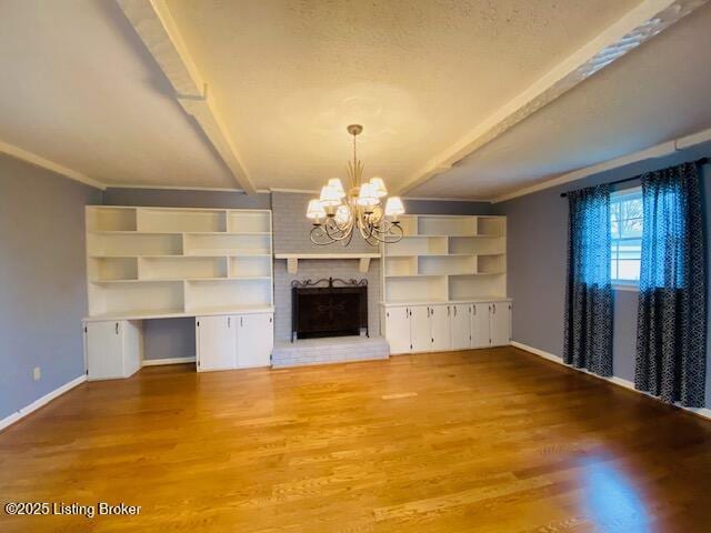 unfurnished living room with baseboards, beam ceiling, and a notable chandelier