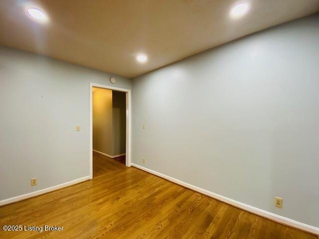 empty room featuring recessed lighting, wood finished floors, and baseboards