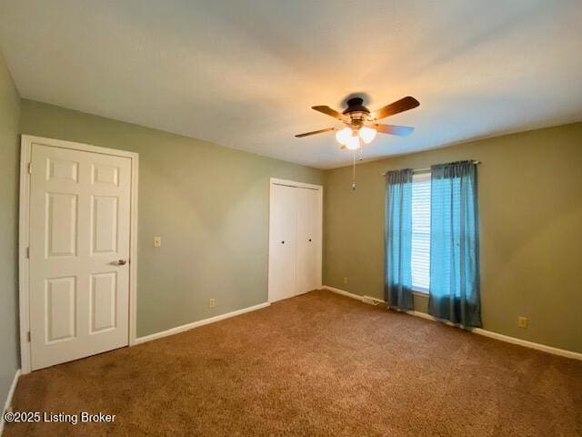 carpeted empty room with baseboards and a ceiling fan