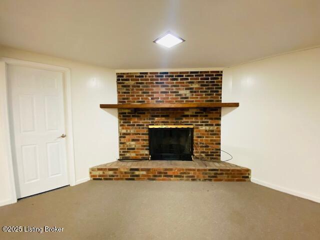 unfurnished living room featuring baseboards, carpet flooring, and a brick fireplace