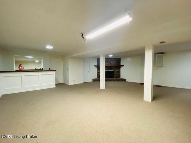 finished below grade area featuring a fireplace and carpet flooring