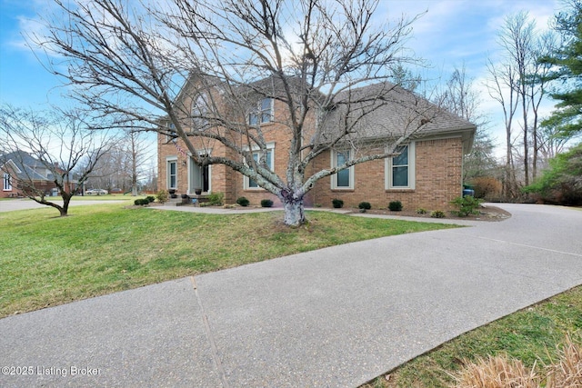 view of front of property with a front lawn and brick siding