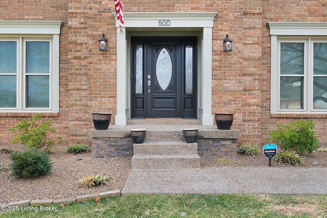 doorway to property featuring brick siding