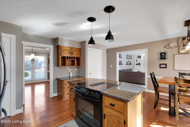 kitchen with pendant lighting, black range with electric cooktop, baseboards, and light wood finished floors