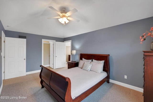 carpeted bedroom with baseboards, visible vents, vaulted ceiling, and a ceiling fan