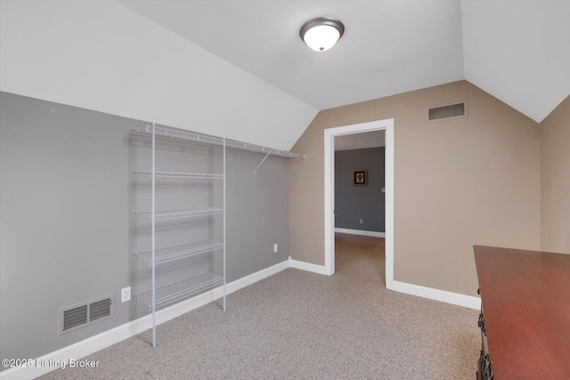 spacious closet featuring lofted ceiling, visible vents, and carpet flooring